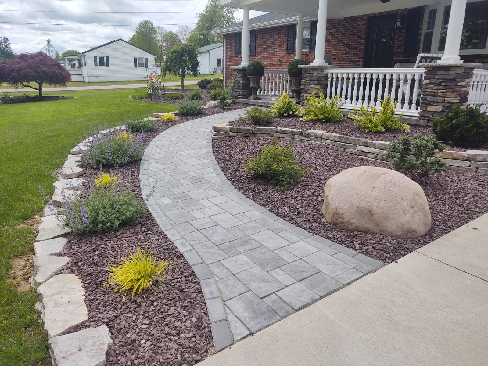Curved paver walkway and front-yard planting by Dave's Landscaping